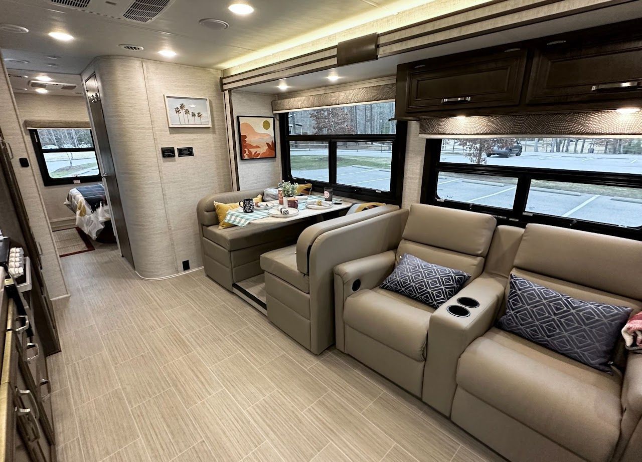 A living room in a rv with a couch, chairs and a table.