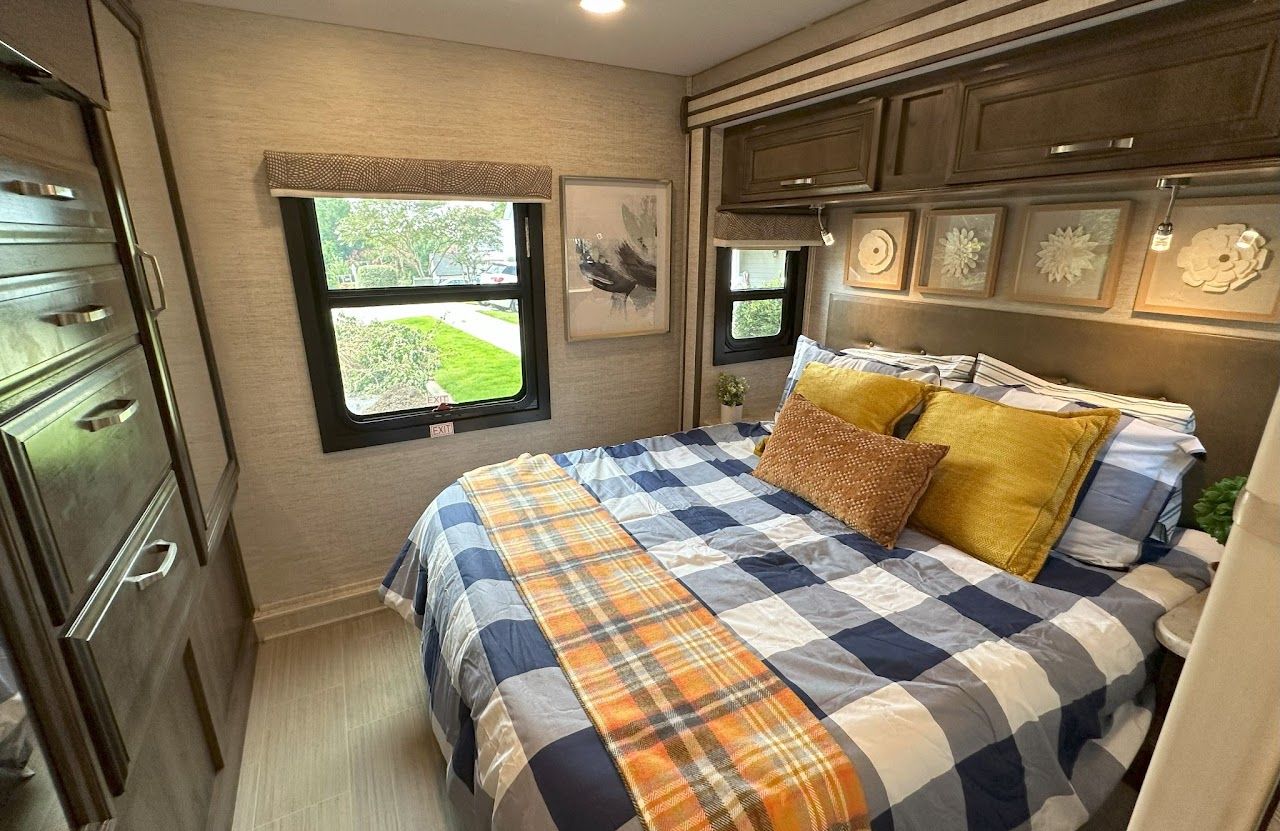 A bedroom in a rv with a bed and a window.