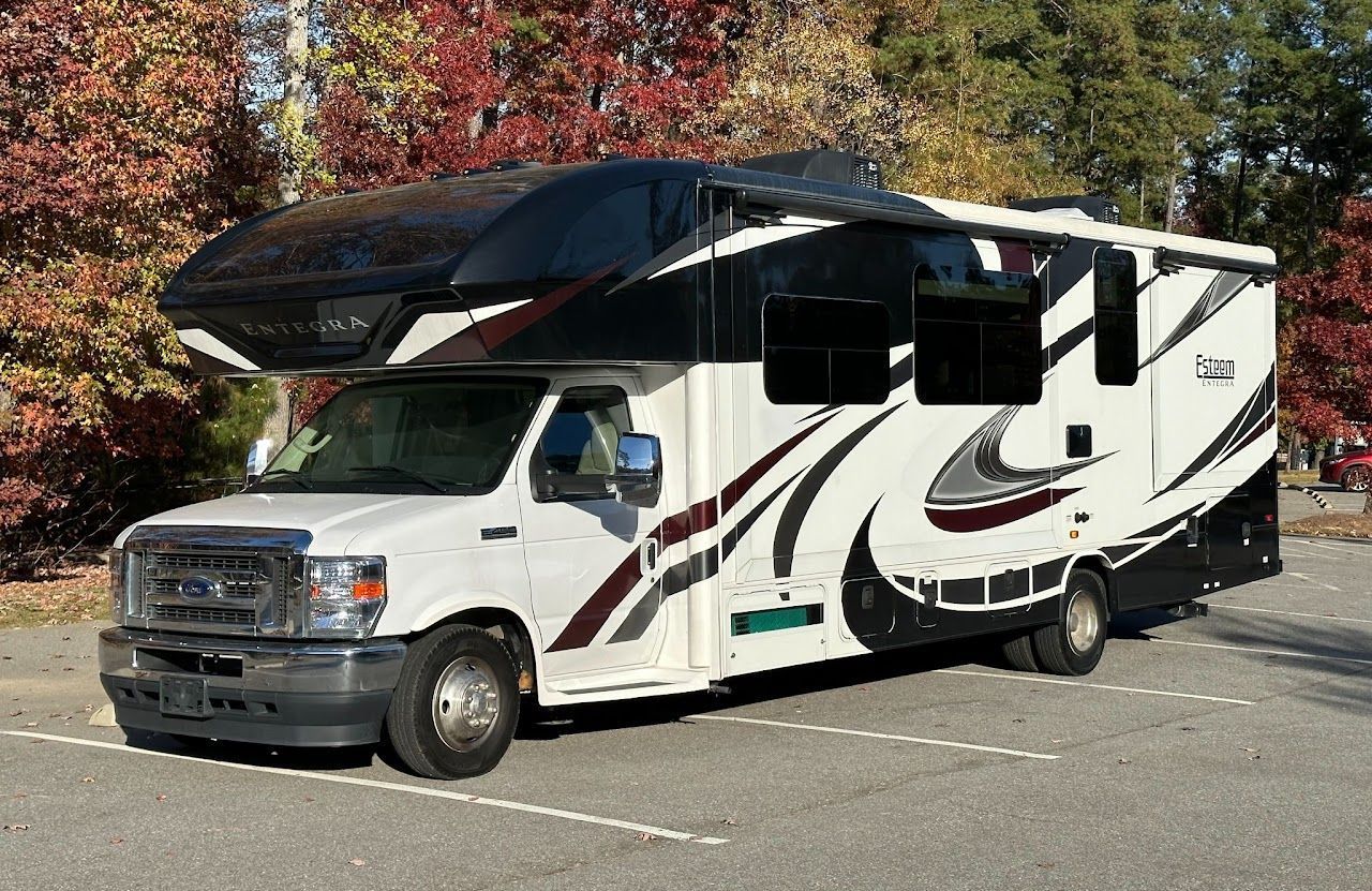 A large white rv is parked in a parking lot.