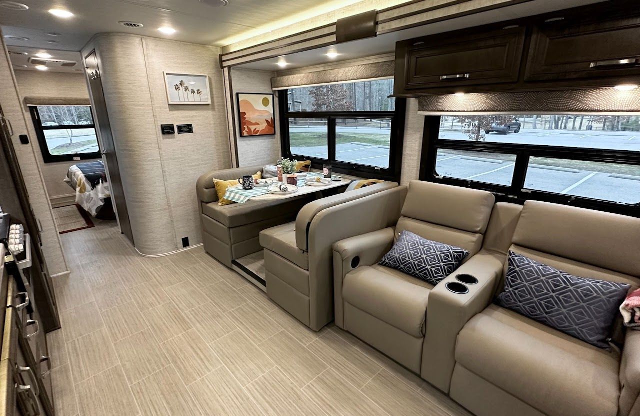 A living room in a rv with a couch , chairs and a table.