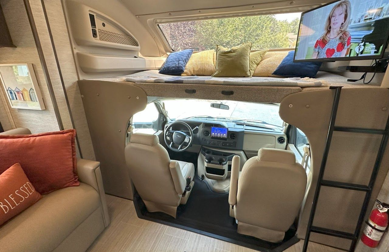 The inside of a rv with a couch and a television.