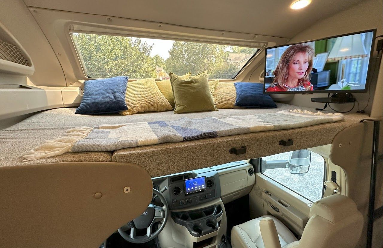 A rv with a bunk bed and a flat screen tv.