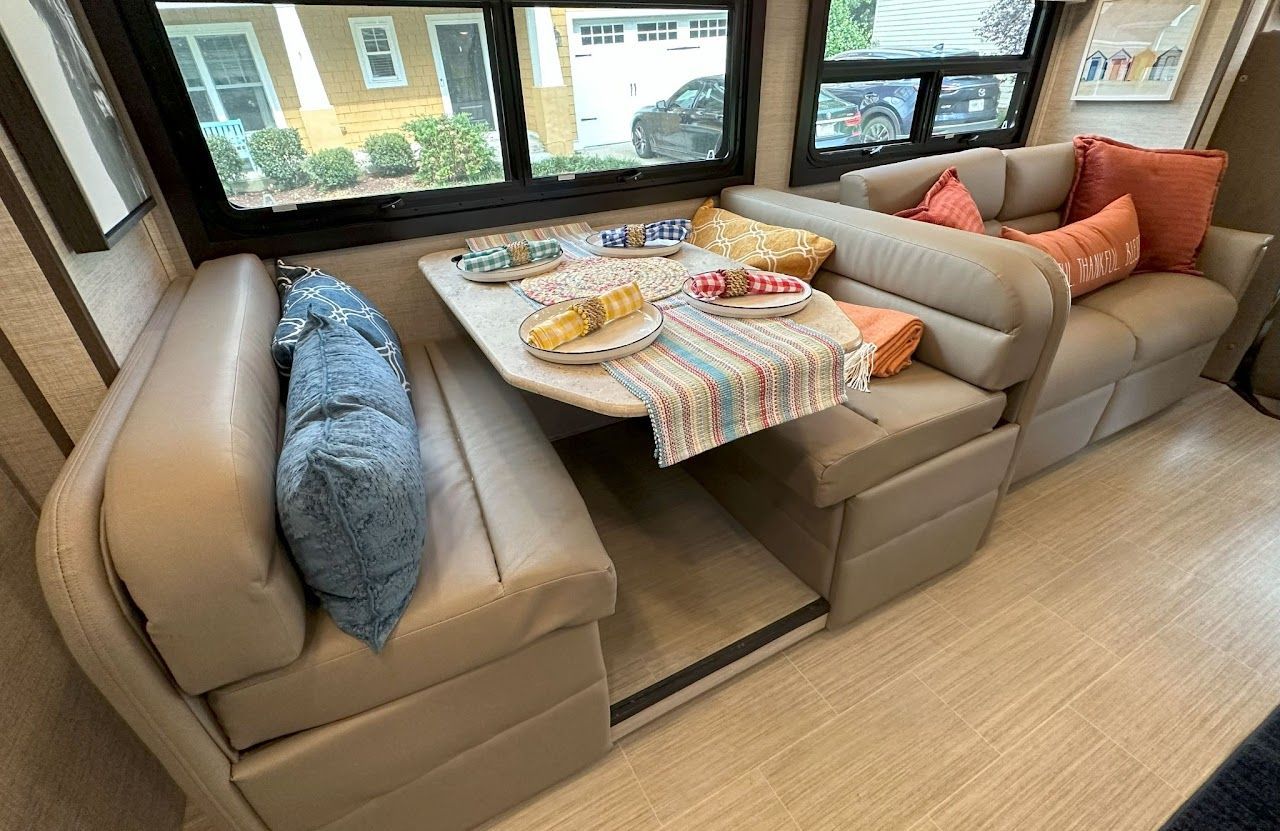 A dining area in a rv with a table and couch.