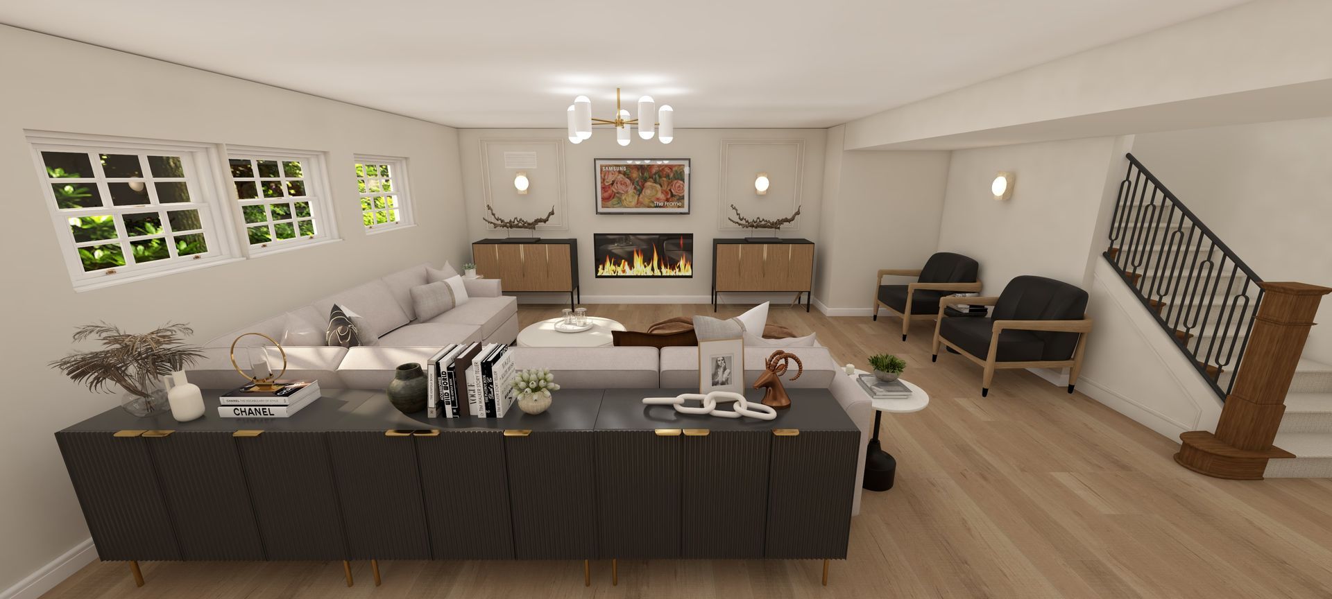 Bright modern living room with gray sofa, dark coffee table, wall art, windows, and staircase with black railing