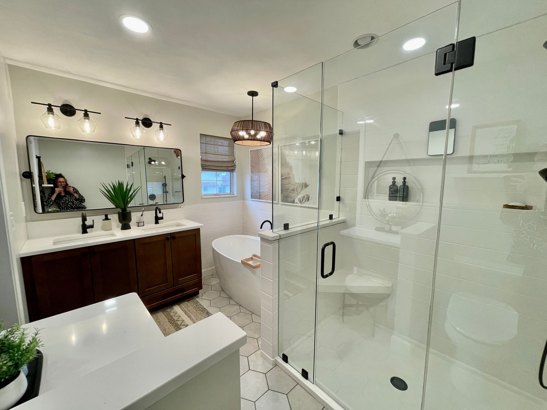 Modern bathroom with a glass shower, a soaking tub, and a dark wooden vanity.