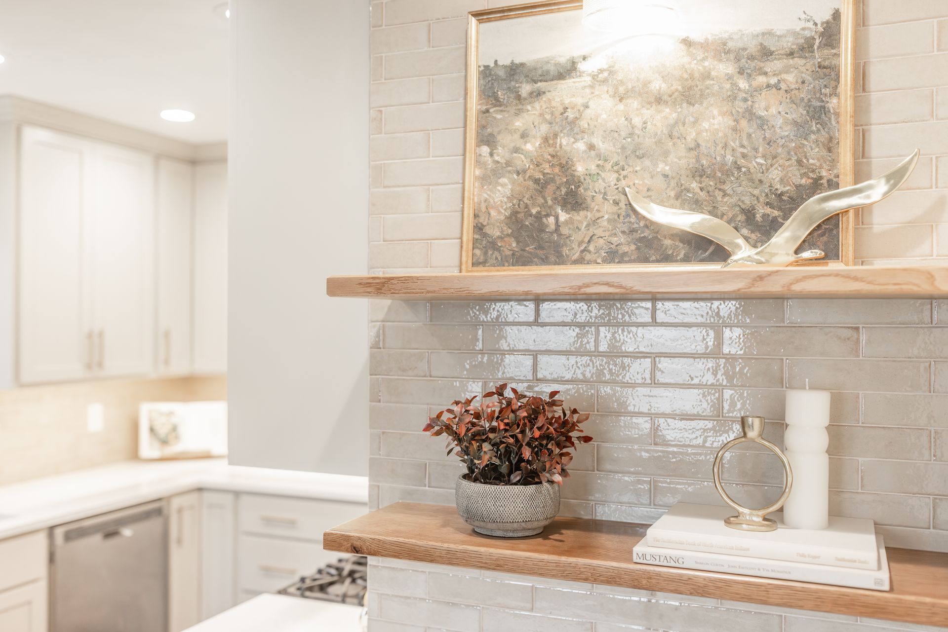 Kitchen with tiled backsplash, wooden shelves, artwork, and decorative items.