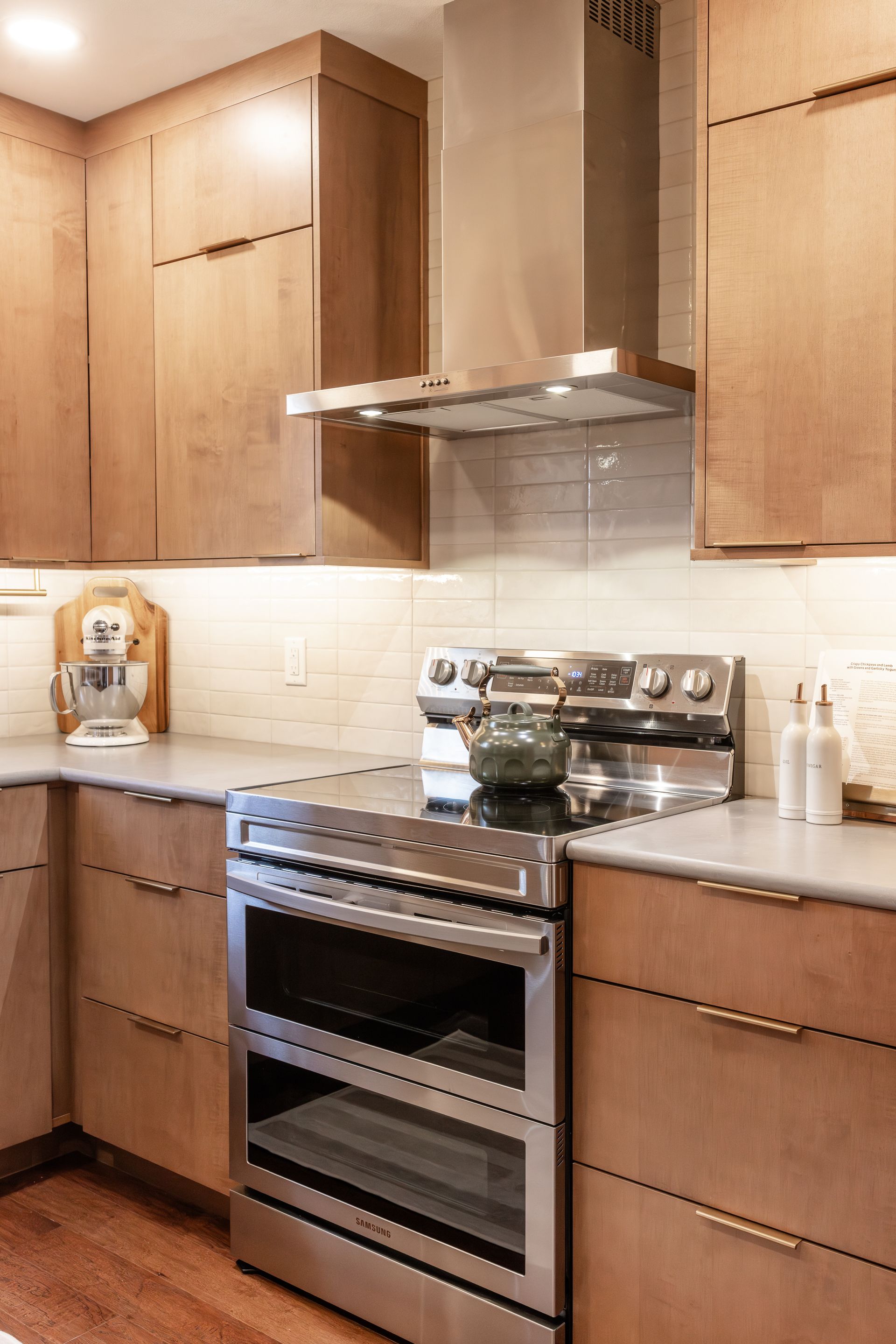 Modern kitchen with wood cabinets, stainless steel appliances, and gray countertops.