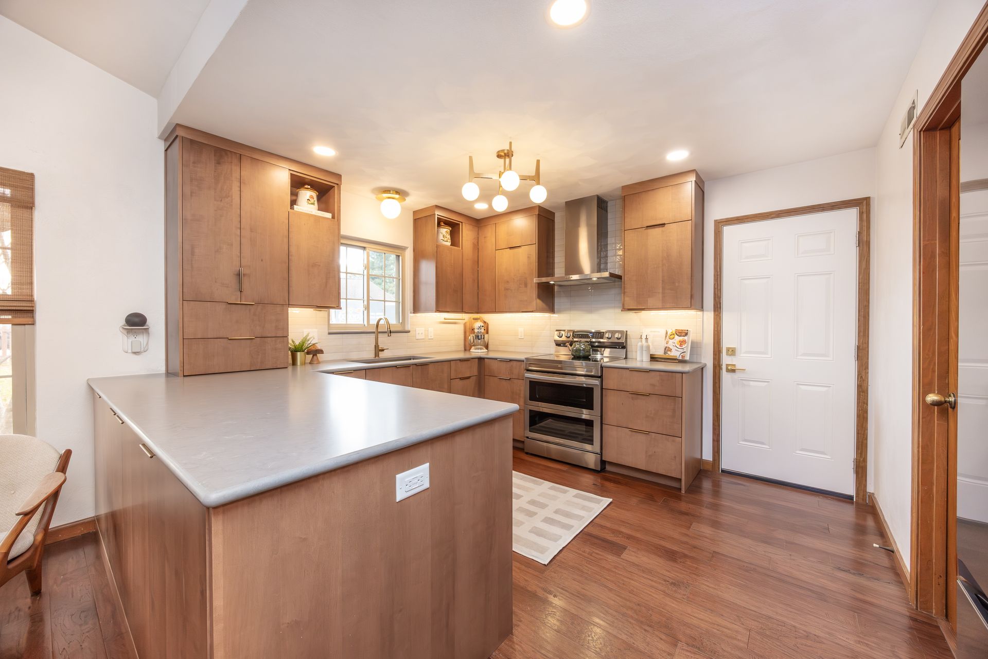 Modern kitchen with wood cabinets, island, and stainless steel appliances.