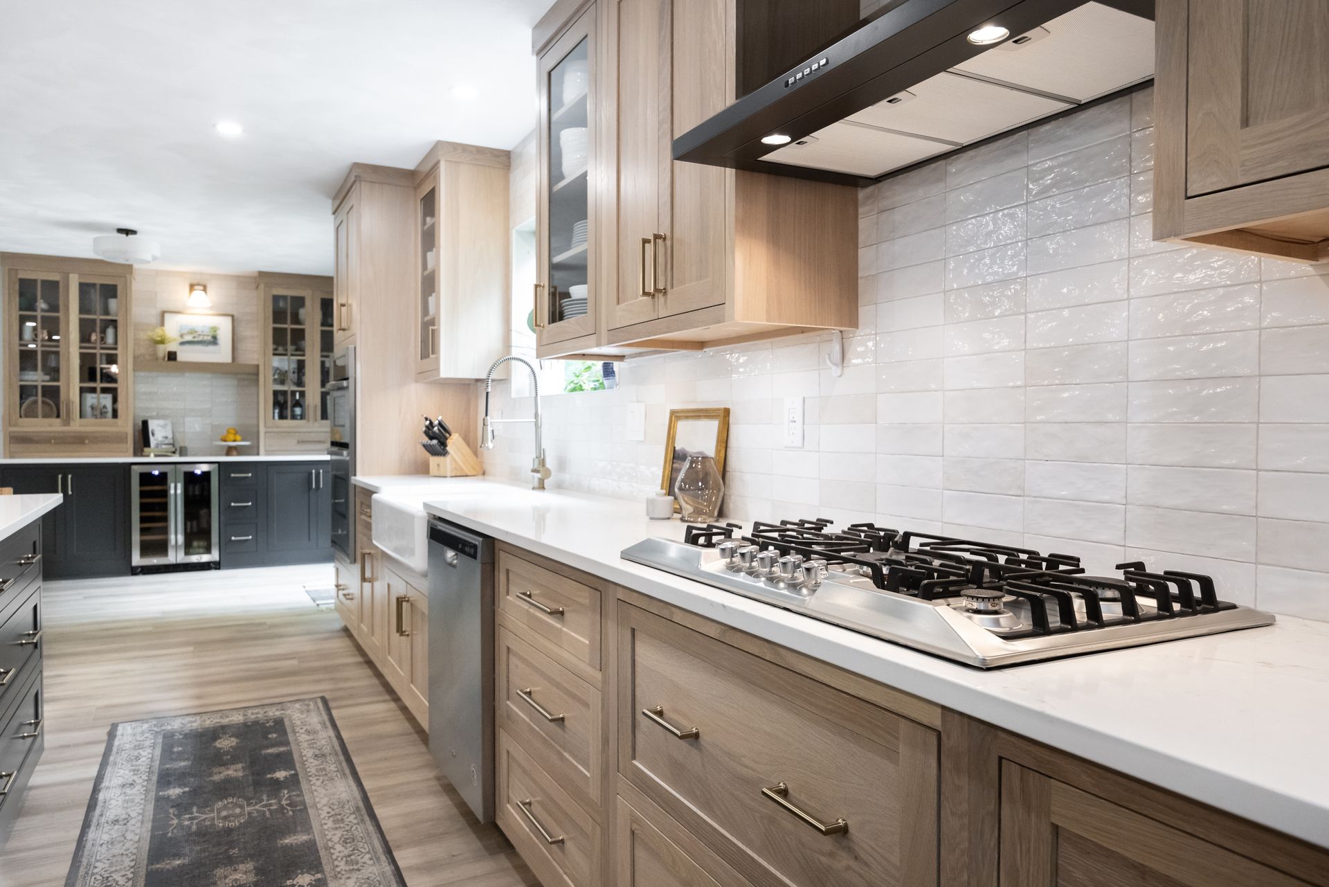 Modern kitchen with wood cabinets, white countertops, and white tile backsplash.