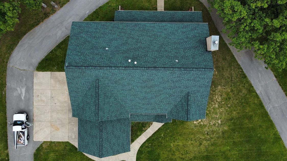 Overhead view of a house with green roof and attached driveway and walkway.