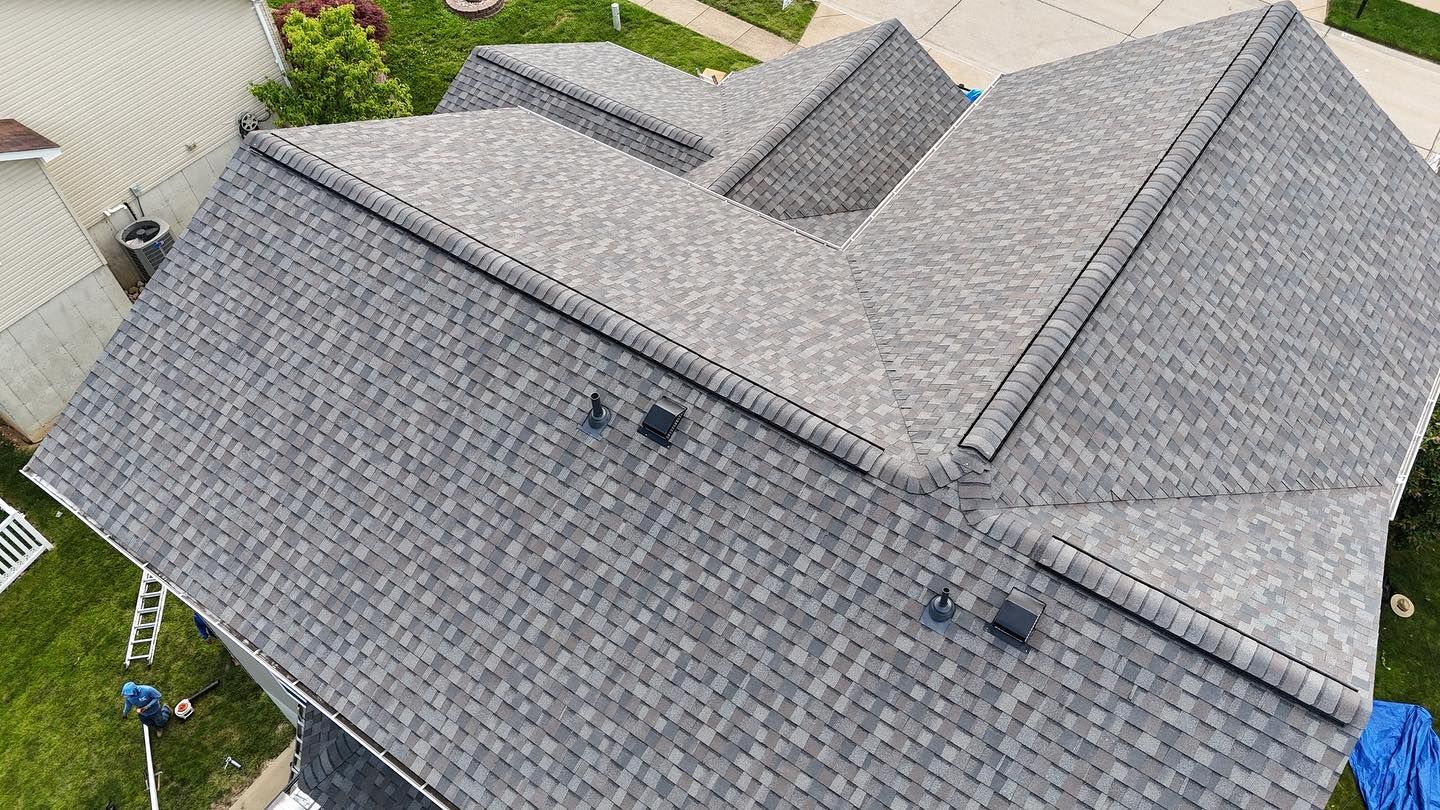 Gray asphalt shingle roof on a house, angled view. Several vents and chimneys are visible.