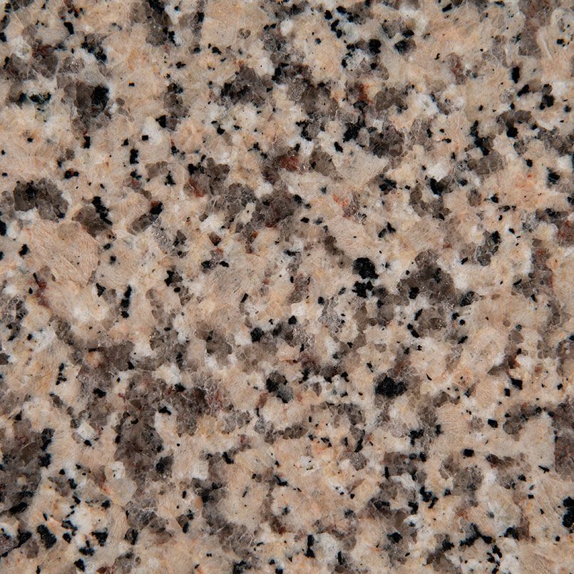 Close-up of granite surface with speckled tan, black, and gray mineral patterns.