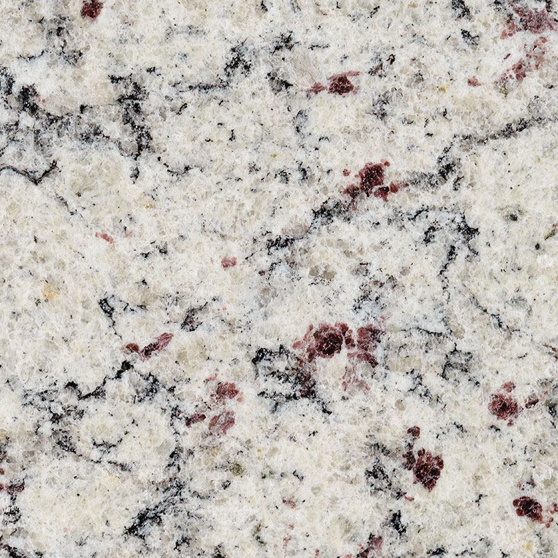 Close-up of granite countertop with white, black, and maroon speckles and veins.