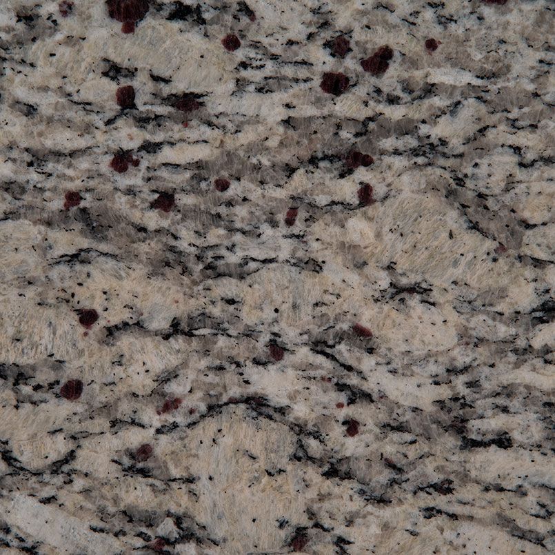 Close-up of granite surface with beige and grey base, black veining, and red/burgundy flecks.