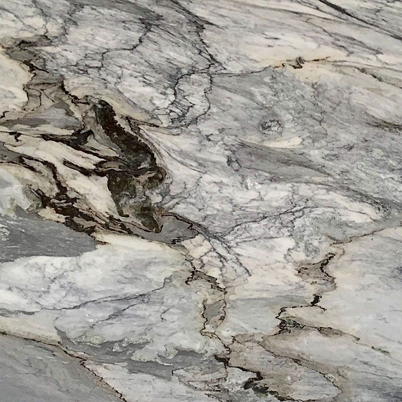 Close-up view of a marble surface, displaying gray, white, and brown veining patterns.