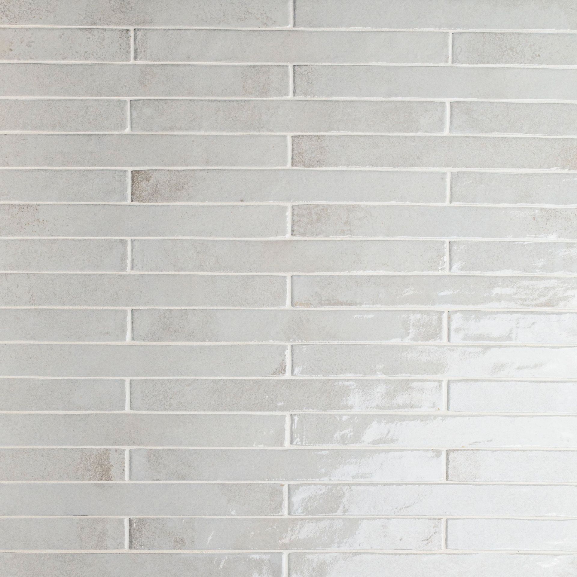 Light gray brick-style tile wall with slightly uneven, long, horizontal pieces and white grout lines.