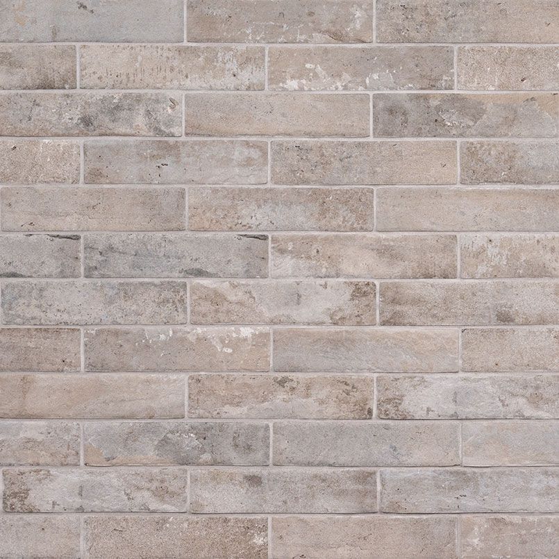 Brick wall with varying shades of beige and gray.