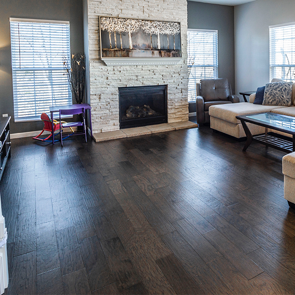 Living room with dark wood floor, fireplace, and beige sectional sofa.