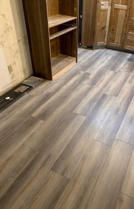 Wooden floor with a bookcase and partially visible cabinets.