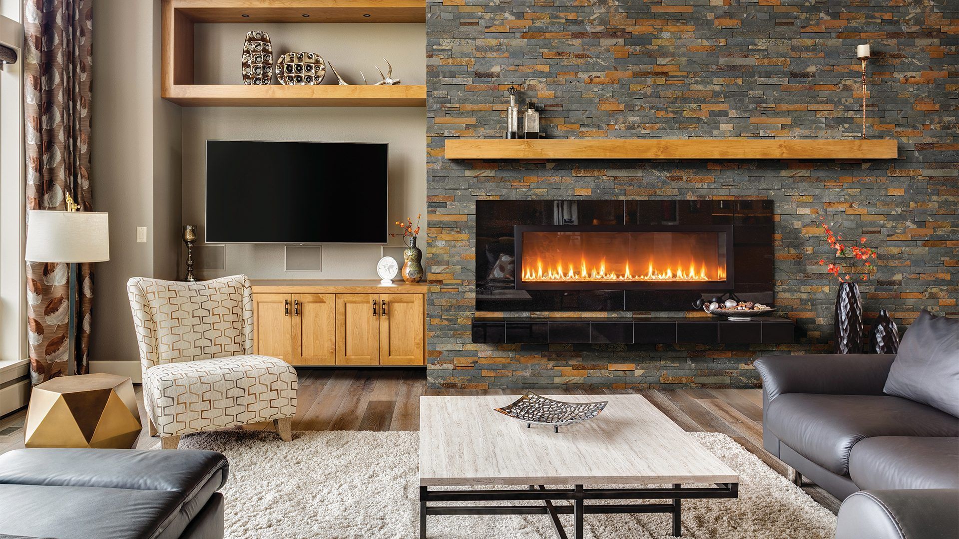 Living room interior with stone fireplace, TV, and modern furniture.