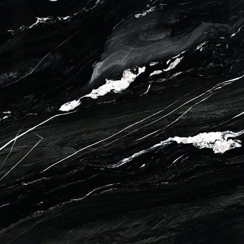 Black marble surface with white veins and streaks.