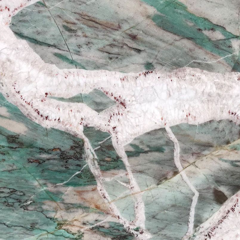 Green and white marble with veining and dark flecks.