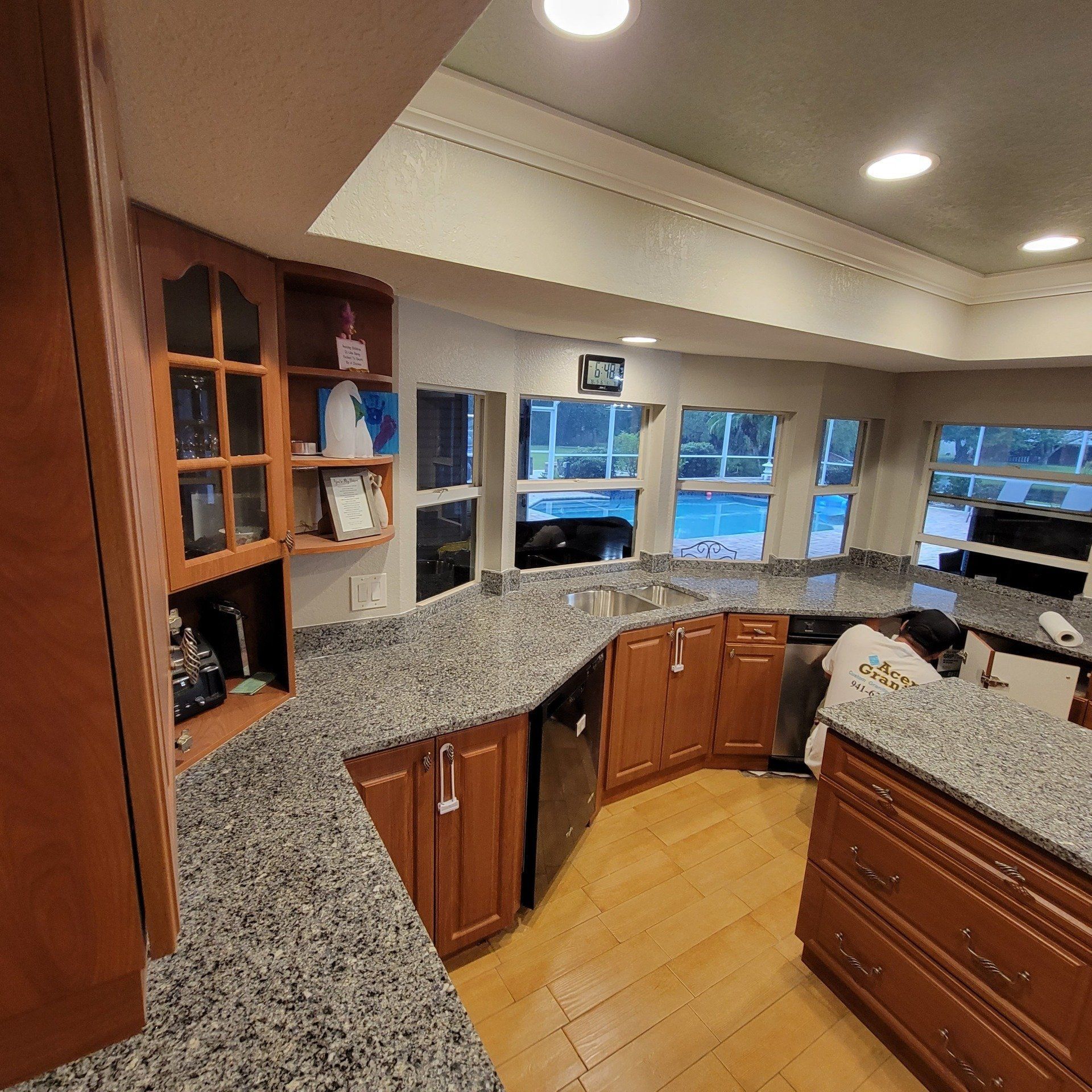 Kitchen with granite countertops, wood cabinets, and large windows.