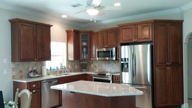 Kitchen with dark wood cabinets, stainless steel appliances, and a granite island.