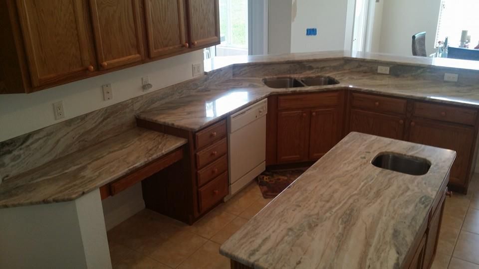 Kitchen with tan granite countertops, wooden cabinets, and a white dishwasher.