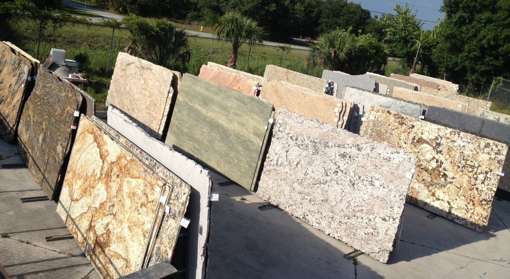 Various granite slabs displayed outdoors, showcasing different colors and patterns.