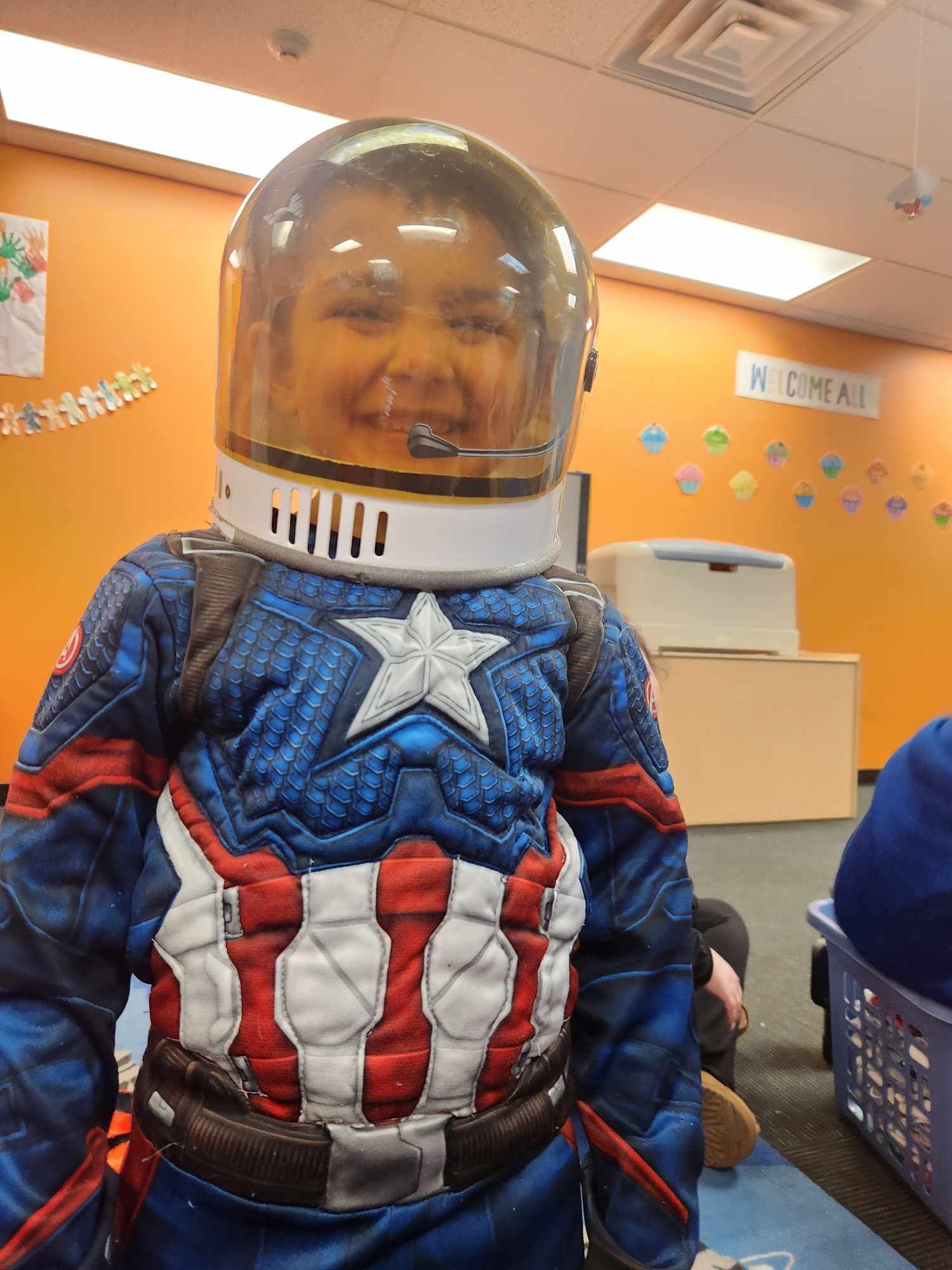 A child dressed as captain america wearing a helmet