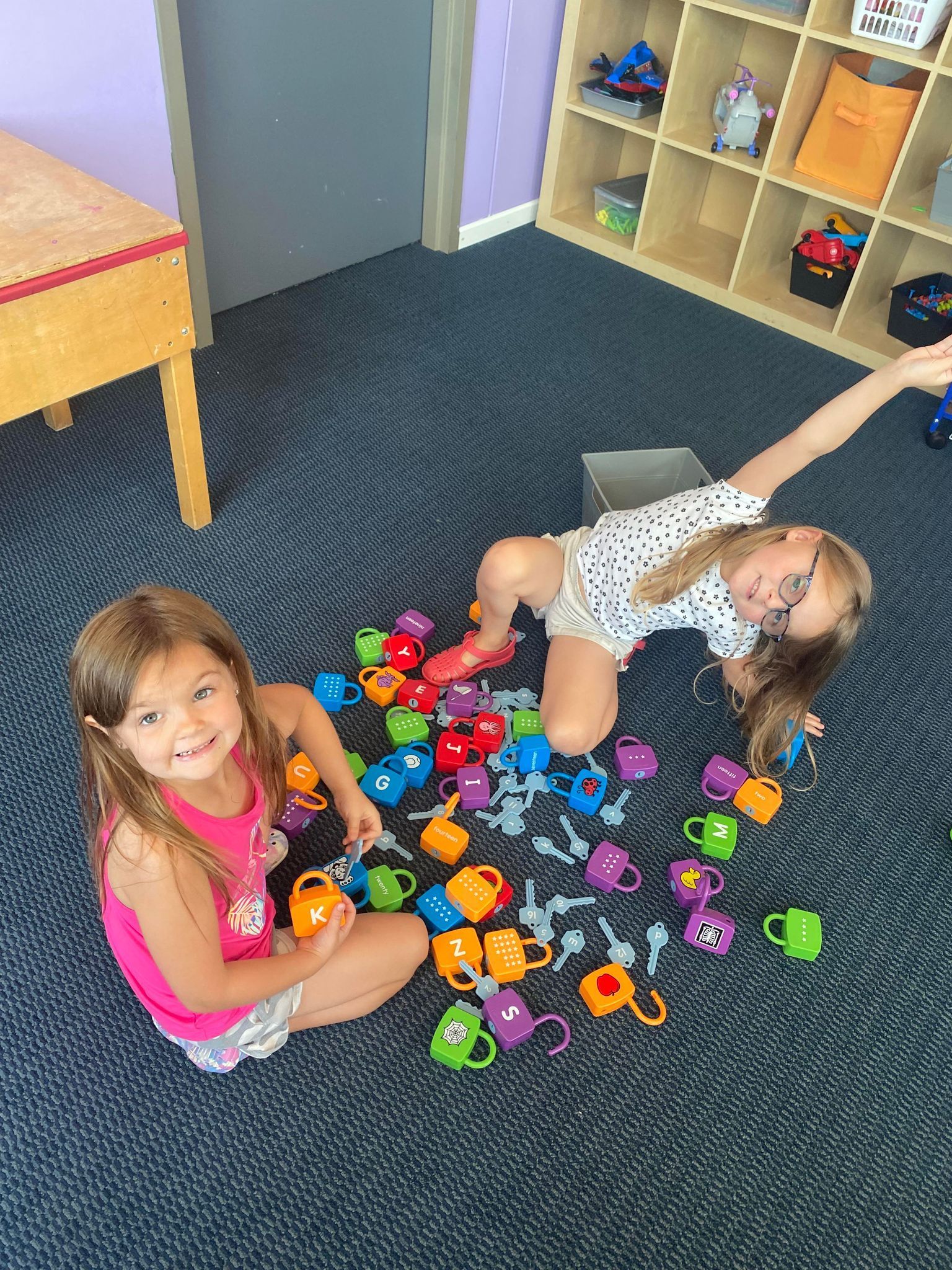 Two little girls playing with lock and key toys
