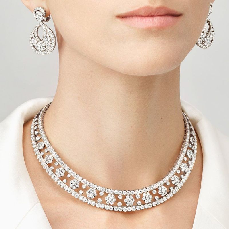 A woman wearing a diamond necklace and earrings