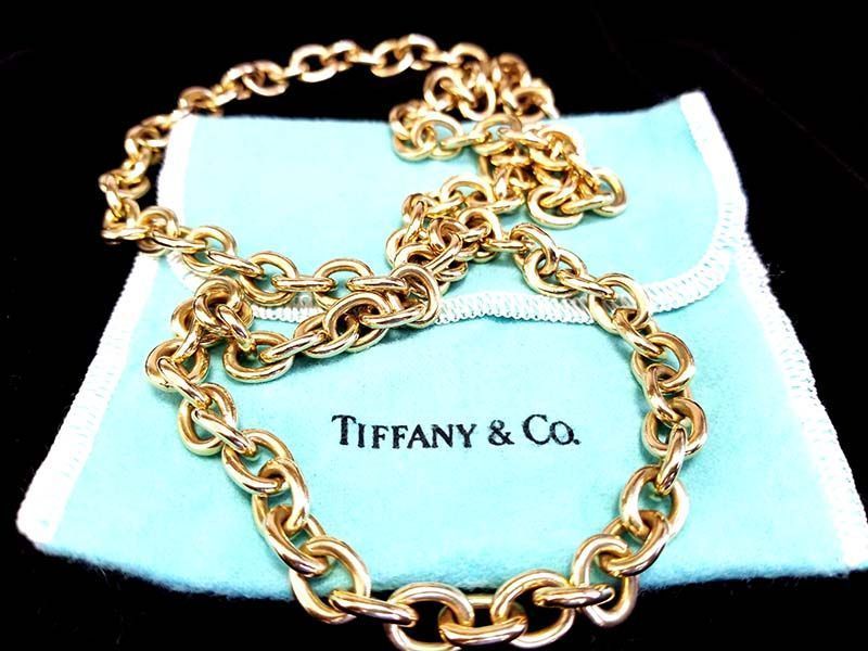 A tiffany & co. necklace is sitting on a blue cloth