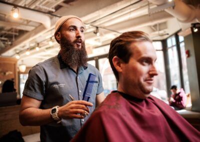 A man is getting his hair cut at a barber shop.