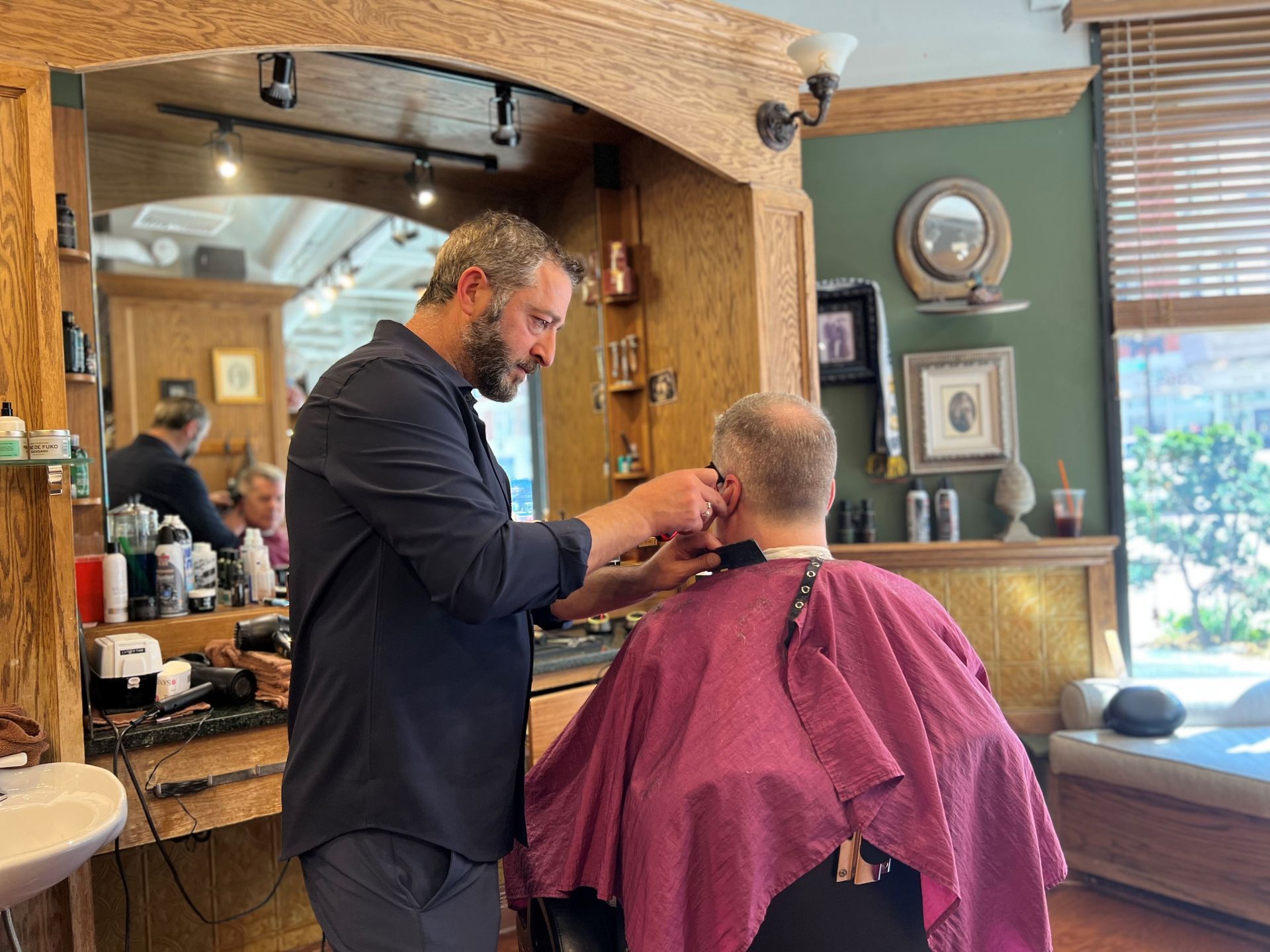 A man is having his hair styled