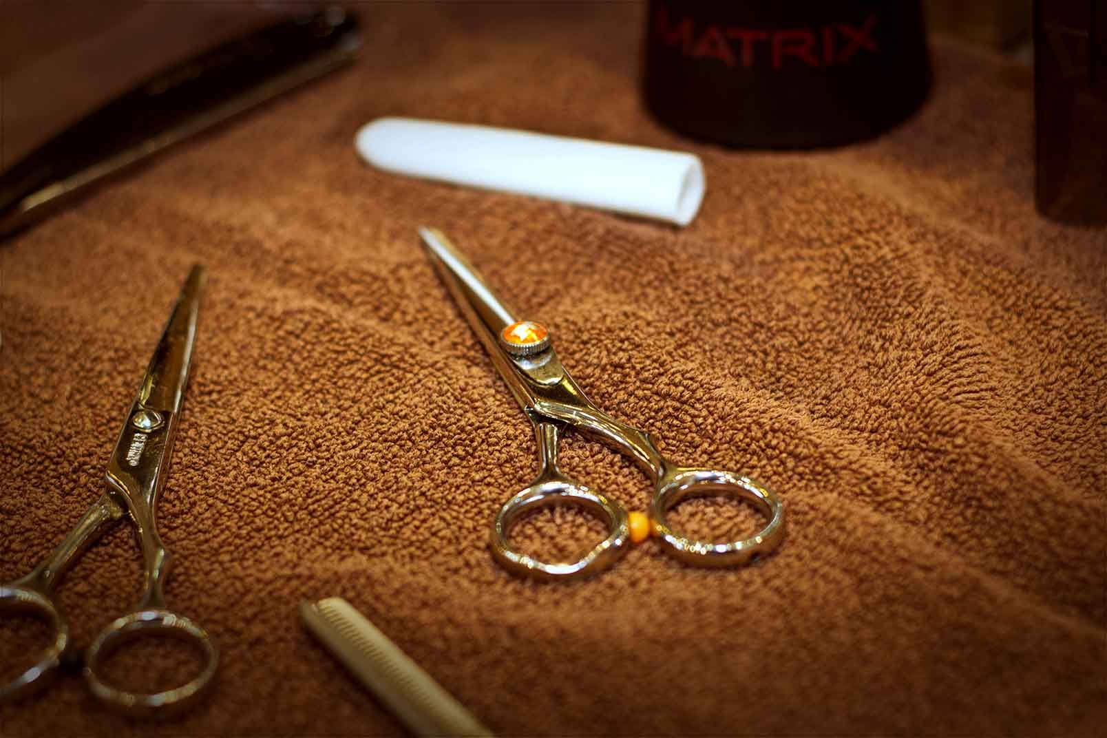 A pair of scissors sitting on top of a brown towel.