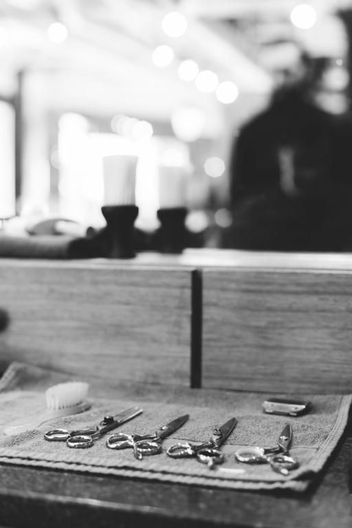 A black and white photo of scissors on a table in a barber shop.