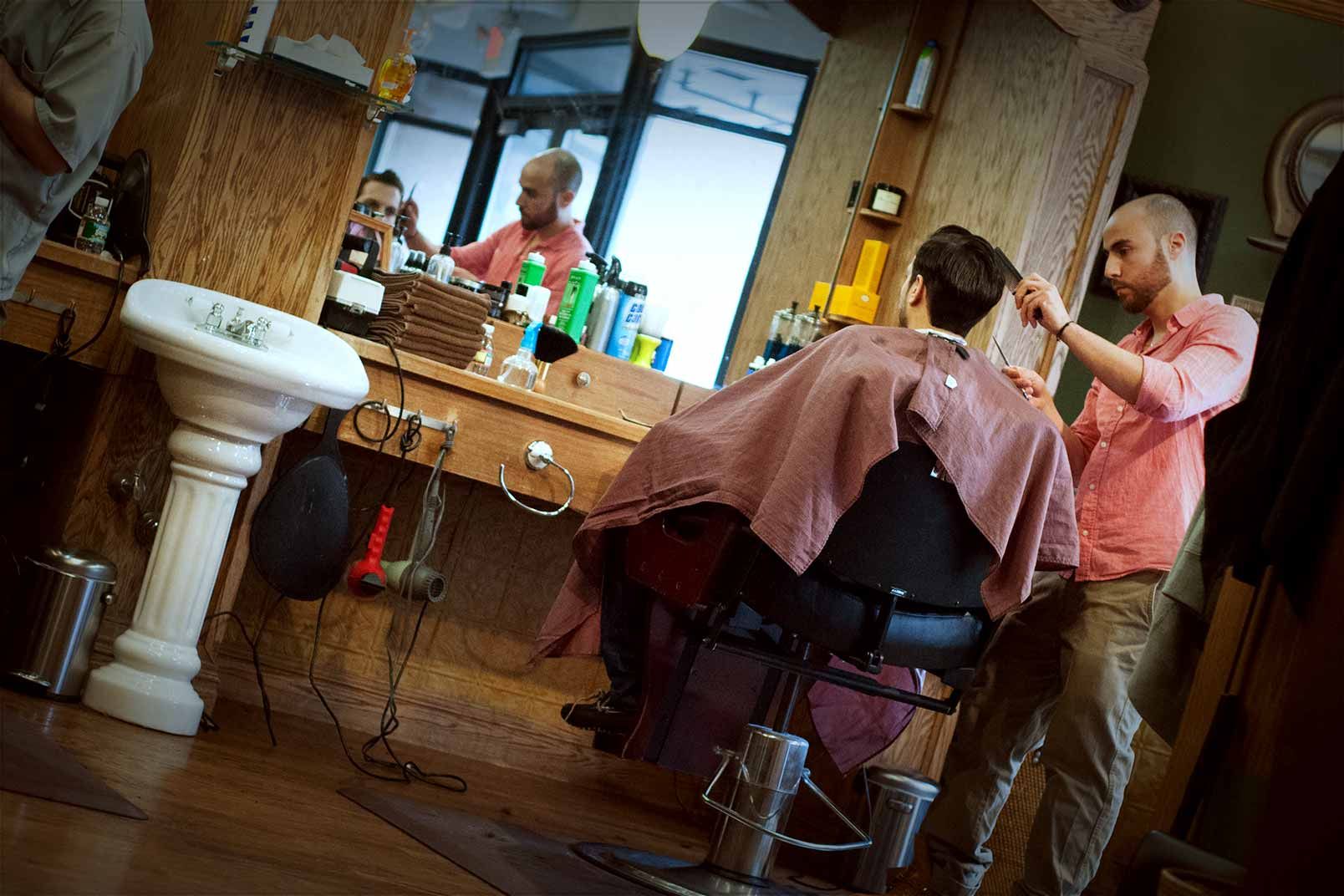 A man is getting his hair cut at a barber shop