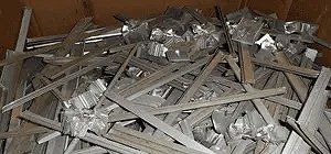 Pile of metallic scrap, possibly aluminum, in a cardboard box.