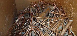 Copper pipes and wires in a container, close-up.