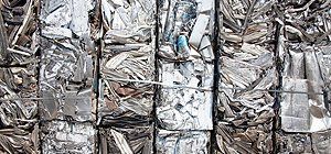 Compressed, shiny metal scraps tightly bundled together.