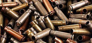 Pile of spent bullet casings in various colors, close up.