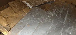 Silver and gold-colored metal sheets laid out with some white material in the background.
