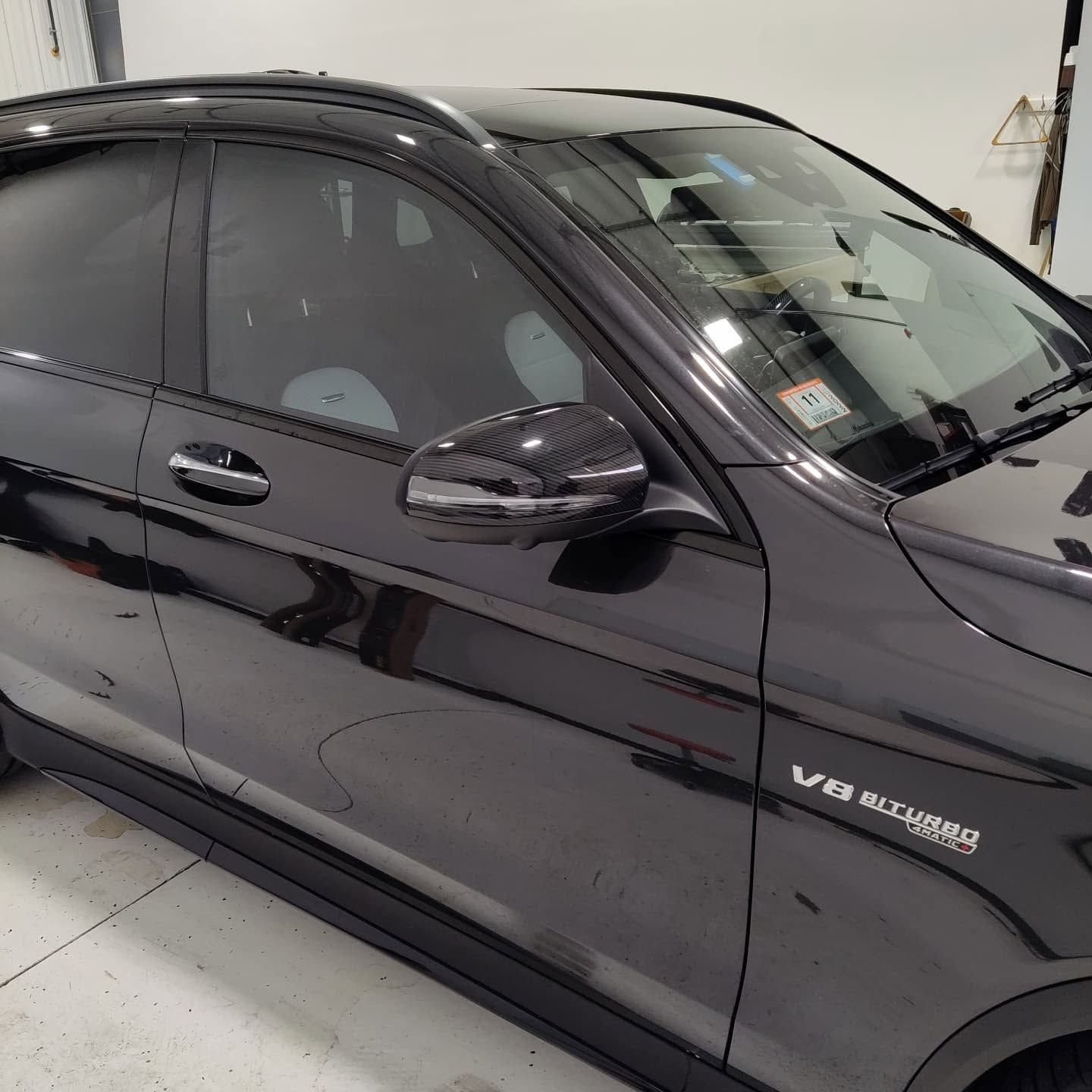 Black Mercedes SUV in a garage, side view with tinted windows and chrome trim.