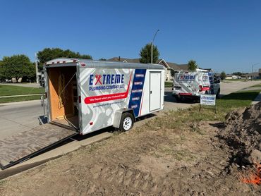 A trailer with the word extreme on it is parked on the side of the road.