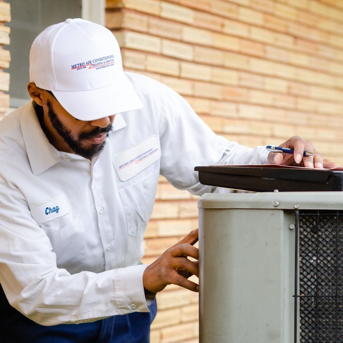 HVAC technician inspecting an outdoor AC unit.