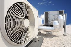 Rooftop HVAC units with large fans and silver ductwork under a blue sky
