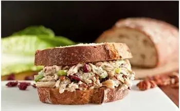 Chicken salad sandwich on toasted bread with cranberries and pecans.