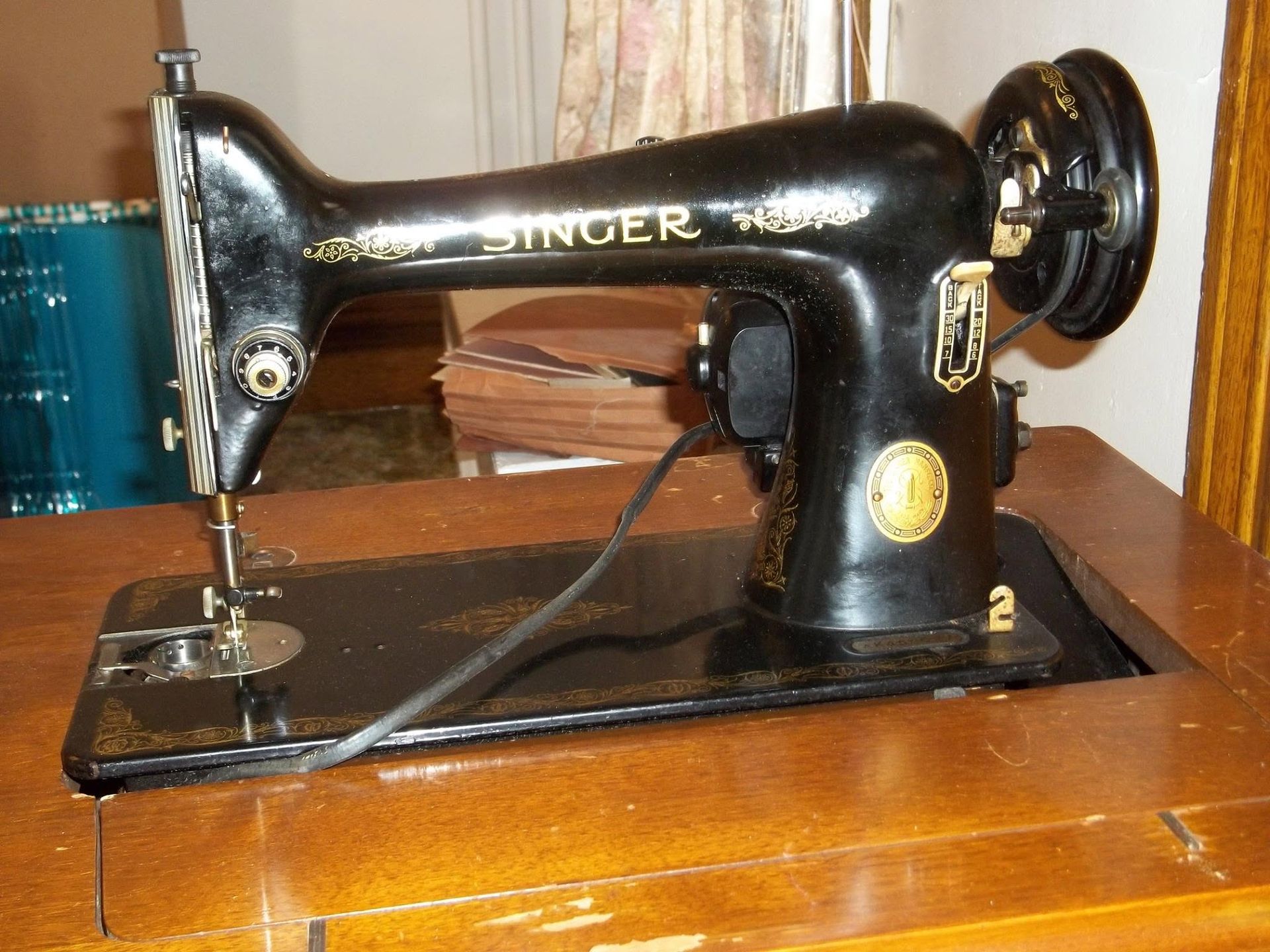 Vintage black Singer sewing machine on a wooden table.